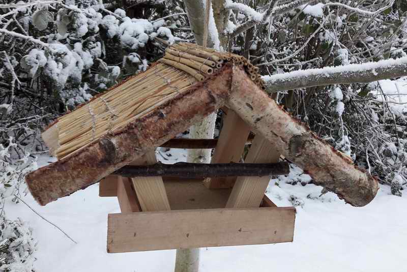 Vogelhaus „Reiherholz“ mit Reetdach im Winter